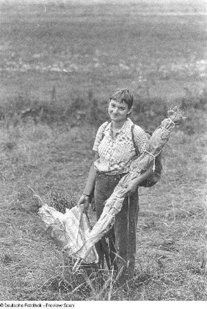 Jana Richter mit gesammelten Pflanzen und Campingausrüstung auf einer Wiese, aufgenommen in Eisenach