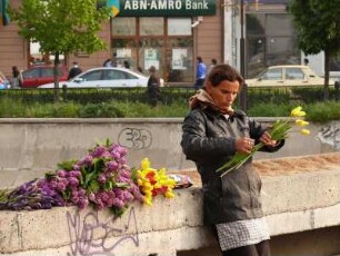Frau verkauft Blumen aus dem eigenen Garten im Stadtzentrum an Passanten