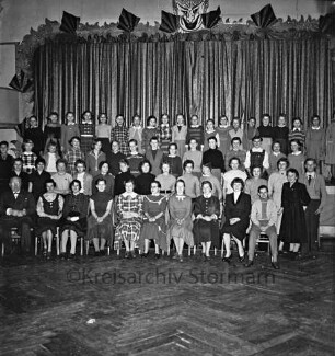 Oldesloer Jugendchor: Hotel Oldesloer Hof: Saal: vor Bühne: Probe für Faschingsveranstaltung: Gruppenaufnahme mit Musikdirektor August König