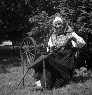 Insel Runö, Bauersfrau in Volkstracht am Spinnrad