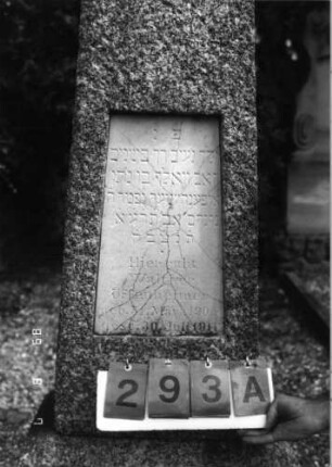 Grabstein 293 (Index: 99797081) Material: Granit, weiße Marmorplatte Zustand: Platte gesprungen, sonst gut Maße HxBxT: 146x67x31 cm Beschreibung: konische Stele, Sockel, giebelartiger Abschluß, Schriftplatte: Grabstein 293A