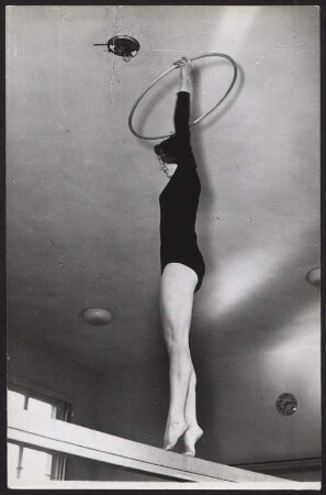 Rhythmische Sportgymnastik mit Reifen auf dem Schwebebalken
