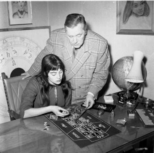 Knud Hallerstroem unterrichtet eine junge Frau, wie man im Roulette die Chips setzt