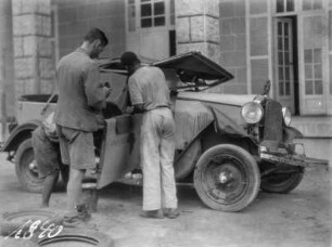 Autoreparatur : Drei Personen reparieren einen lädierten Wagen der Schomburgk-Expedition