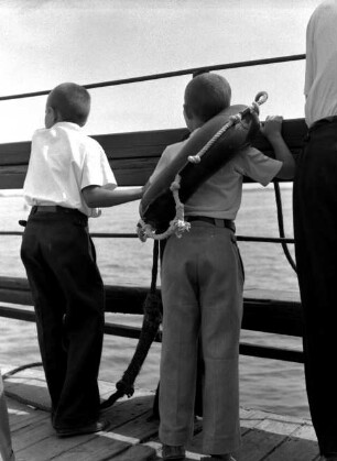 Junge mit Rettungsring an der Reling eines Schiffes auf der Wolga
