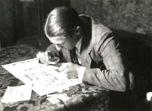 Briefmarkensammler beim Markenbetrachten mit der Lupe