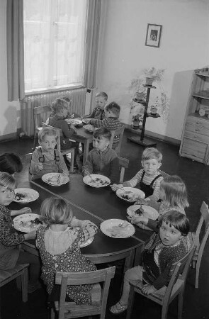 Essende Kinder im Gruppenraum des Kindergartens