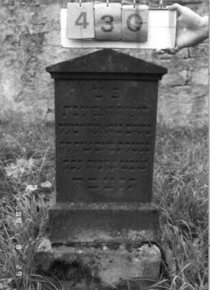 Grabstein 430 (Index: 100107949) Material: roter Sandstein Zustand: gut, Stele scheint auf dem Sockel schräg zu sitzen Maße HxBxT: 86x38x23 cm Beschreibung: Stele, überkragender Giebelabschluß, getreppter Sockel Besonderheit: Kindergrab: Grabstein 430