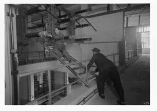 Industrie-Kraftwerk. 100-kV-Haus, Elektromonteur und Helfer bei Montagearbeiten : Lauta (Niederlausitz). Industrie-Kraftwerk. 100-kV-Haus, Elektromonteur und Helfer bei Montagearbeiten