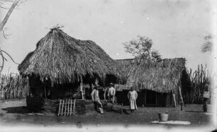 Station Mafi : Zwei Forschungsreisende stehen an einem Haus der Deutsch-Ostafrikanischen Gesellschaft (DOAG) Station Mafi