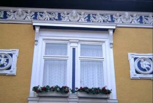 Detail voriges Bild: Stuckfries unter der Traufe, Stuckmedaillons neben Fenster