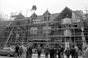 Kreissparkasse Stormarn: Paul-von-Schoenaich-Straße: Neubau: Richtfest: eingerüsteter Rohbau mit Richtkrone: auf Gerüst Arbeiter: vorn Gäste