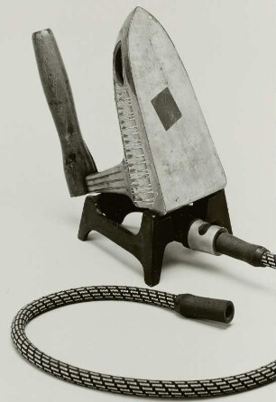 Gas-Bügeleisen (Haushalt-Bügeleisen) mit externer Wärmequelle (Gasbrenner, zugleich Ablage). Um 1900; Stahl, Holz : Gas-Bügeleisen (Haushalt-Bügeleisen) mit externer Wärmequelle (Gasbrenner, zugleich Ablage). Um 1900; Stahl, Holz. Dresden: Privatsammlung