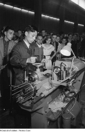 Besucher des chinesischen Pavillons der Leipziger Herbstmesse 1954betrachten die Vorführung einer Industriemaschine