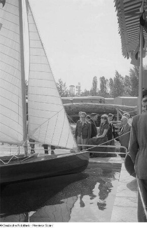 Besucher vor einem Segelboot