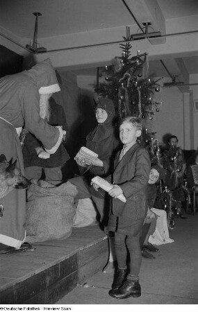 Weihnachtsmann, einem Jungen ein Geschenk überreichend