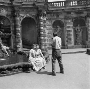 Dresden-Altstadt. Zwinger. Ein Mann fotografiert im Nymphenbad zwei auf dem Rand eines Brunnenbeckens sitzende Frauen