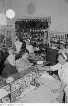 Verkäuferinnen bedienen Kundinnen einer Fleisch- und Wursttheke