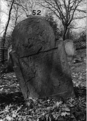Grabstein 52 (Index: 100080784) Material: Sandstein Zustand: völlig abgeblättert, nur einzelne Buchstaben erkennbar Maße HxBxT: 113x63x13 cm Beschreibung: Stele, eingezogener hufeisenförmiger Abschluß, eingetieftes Schriftfeld rechteckig Besonderheit: Benjamin -> Gattenname oder Vatername ?: Grabstein 52