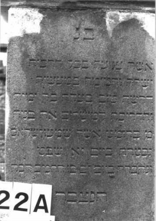 Grabstein 22 (Index: 100114434) Material: Kalkstein, Giebel: Sandstein Zustand: leicht verwittert Maße HxBxT: 175x63x26 cm Beschreibung: Stele, getreppter Sockel, Giebel Symbolik: fünfzackiger Stern Besonderheit: Giebel gehört vermutlich nicht zum Stein: Grabstein 22A
