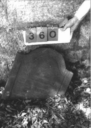 Grabstein 360 (Index: 99609997) Material: Sandstein Zustand: Stele abgebrochen, Unterteil unter Nr. 293 Maße HxBxT: 47x50x9 cm Beschreibung: Oberteil einer Stele, Segmentbogenabschluß, Schriftfeld eingetieft, Unterteil unter Nr. 293 Besonderheit: ergänzt nach Gräberliste: Grabstein 360