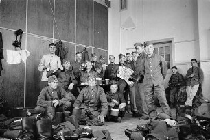Zweiter Weltkrieg. Niederlande unter deutscher Besatzung. Wehrmachtsangehörige in einer Unterkunft, vielleicht einer Turnhalle (wohl bei Den Haag). Ansicht mit Akkordeonspieler