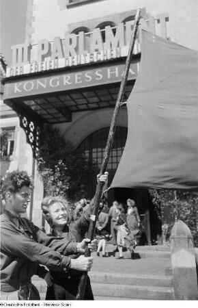 Jugendliche mit Pionierflagge vor dem Eingang zu Kongreßhalle