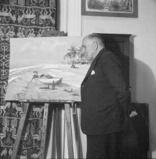 Der Maler Prof. Ernst Vollbehr (1876-1960) in seiner Wohnung vor einer Staffelei stehend