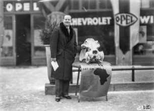 Mann neben Tierschädel : Mann neben einem Tierschädel, möglicherweise von einem Nilpferd, vor der Opel Filiale Eduard Winter in Berlin.