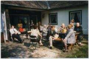 Familie sitzt draußen vor dem Haus (Sonderthema: Familienbilder)
