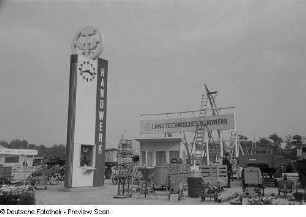 Ein Besucher auf dem Freigelände der Technischen Messe 1953 zwischen landwirtschaftlichen Nutzmaschinen