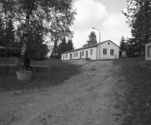 Muldenhammer-Tannenbergsthal-Gottesberg, Zum Pionierlager 20. Ehemaliges Pionierlager "Hanno Günther" des VEB Maxhütte Unterwellenborn (Nachnutzung eines ehemaligen Wismut-Standortes). Unterkunftsbaracke (?). Ansicht vom Zufahrtsweg