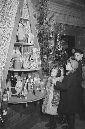 Fünf Kinder vor einer Weihnachtspyramide in der Ausstellung weihnachtlicher Volkskunstarbeiten des Stadtgeschichtlichen Museums