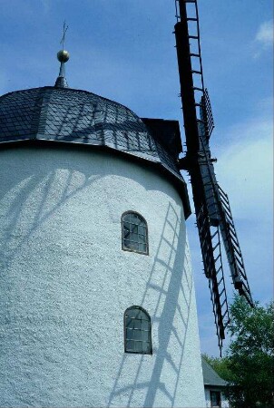 seitlicher Blick auf die Windmühlenflügel am drehbaren Oberteil