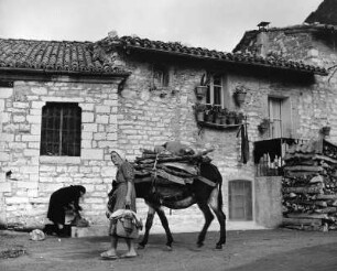 Assisi, Via di Porta Perlici. Straßenbild mit Eselführer