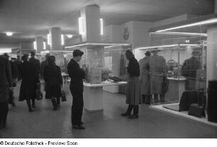 Besucher vor Vitrinen mit Koffern und Taschen