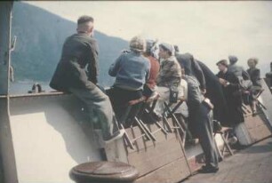 Bordleben. Passagiere auf einem Boot, zum Ufer schauend (vielleicht vor der Küste Norwegens)