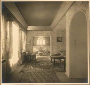 Einfamilienhaus. Inneneinrichtung: Wohnzimmer (?) mit Sofa, Blick in Speisezimmer
