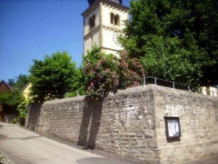 Evangelische Pfarrkirche-Ansicht von Südwesten mit Kirchturm (romanische Gründung) über Kirchhofmauer (Wehrgang mit Steinbrüstung und Schießscharten im 19 Jh abgetragen)