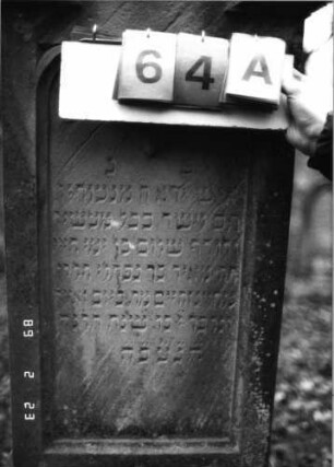 Grabstein 64 (Index: 99751800) Material: Sandstein Zustand: gut Maße HxBxT: 110x47x27 cm Beschreibung: eingezog. Rundbogenabschl. m. Mittel-u. Eckakrot. , Schriftfeld eingetieft, getrepp. Soc Symbolik: Ranken: Grabstein 64A