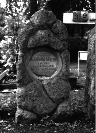 Grabstein 39 (Index: 100101455) Material: Kalkstein, weiße Marmorplatte Zustand: gut Maße HxBxT: 143x62x30 cm Beschreibung: Stele, rustica, ovale Schriftplatte: Grabstein 39