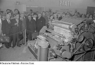 Besucher bei der Vorführung einer Textilmaschine der Firma Pfaff auf der Technischen Messe 1953