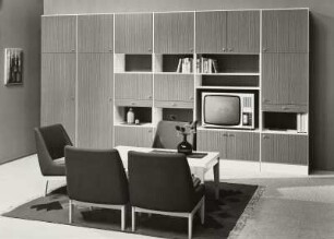 Sessel : Wohnzimmermöbel (1973; Möbelkombinat Nord (MKN)). Ansicht mit Anbauwand, drei Sesseln und Couchtisch