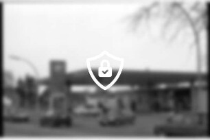BP-Tankstelle: Hamburger Straße: Shop, Waschanlage, Zapfsäulen, Pkws, Kunden, Firmenschild, links Preisschild: vorne auf Straße Autos: 15. März 1990