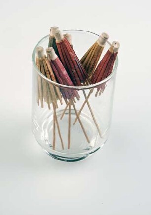 Glas mit sieben Cocktailschirmchen
