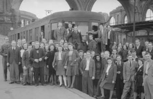 Aufnahmen einer Gruppe junger Leute vor einer Straßenbahn