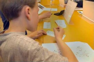 Kinder bei der "Bibliotheksrallye für Kinder" (Kinder lernen die Bibliothek spielerisch auf einer Rallye kennen. Die Maya-Zahlen weisen den Weg) im Serviceraum der Deutschen Fotothek