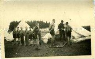 Hitlerjungen mit Anführer beim Appell vor den Zelten am Waldrand