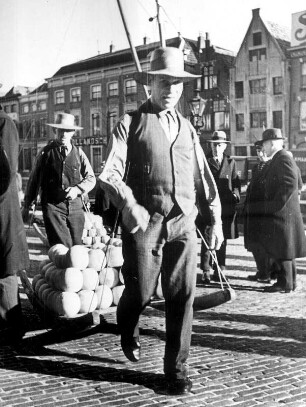 Niederlande. Der des Käses - Alkmaar. Nach dem Wiegen des Käses auf der Stadtwaage wird er von den Käseträgern der gleichnamigen Gilde zum Verladen gebracht. Passanten schauen neugierig zu. Aufgenommen 1936