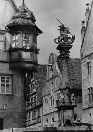 Rothenburg ob der Tauber. Marktplatz. Blick auf das Jagstheimerhaus. Im Vordergrund der 1446 geschaffene St. Georgs- bzw. Herterichsbrunnen